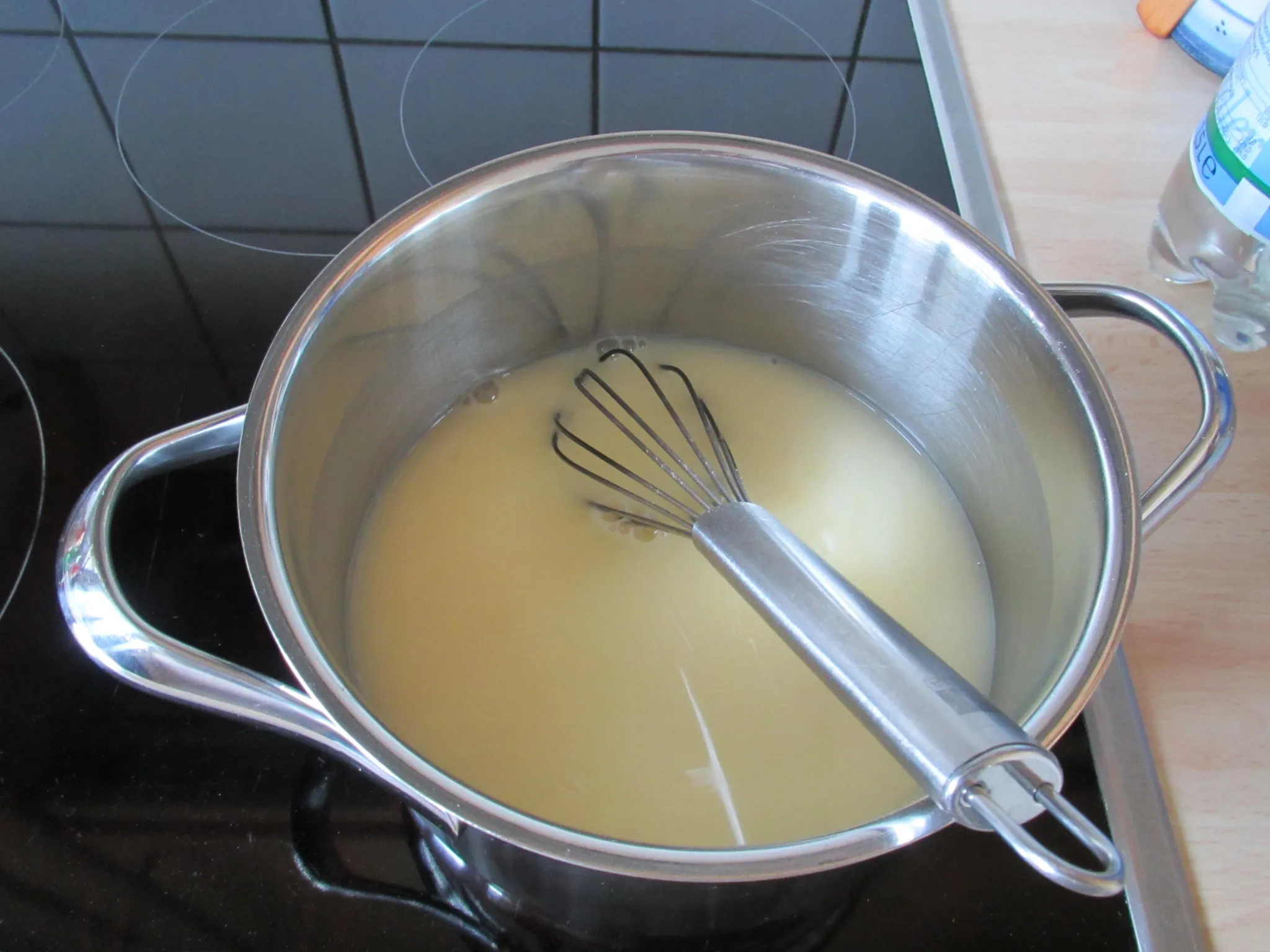Für die Zitronencreme das Puddingpulver mit etwas kaltem Wasser anrühren. Restliches Wasser und Zucker aufkochen, das angerührte Puddingpulver einrühren und aufkochen lassen. Vom Herd nehmen, Eigelb unterrühren, danach Zitronensaft und Butter einarbeiten. Die warme Creme auf den Kuchen streichen und abkühlen lassen.