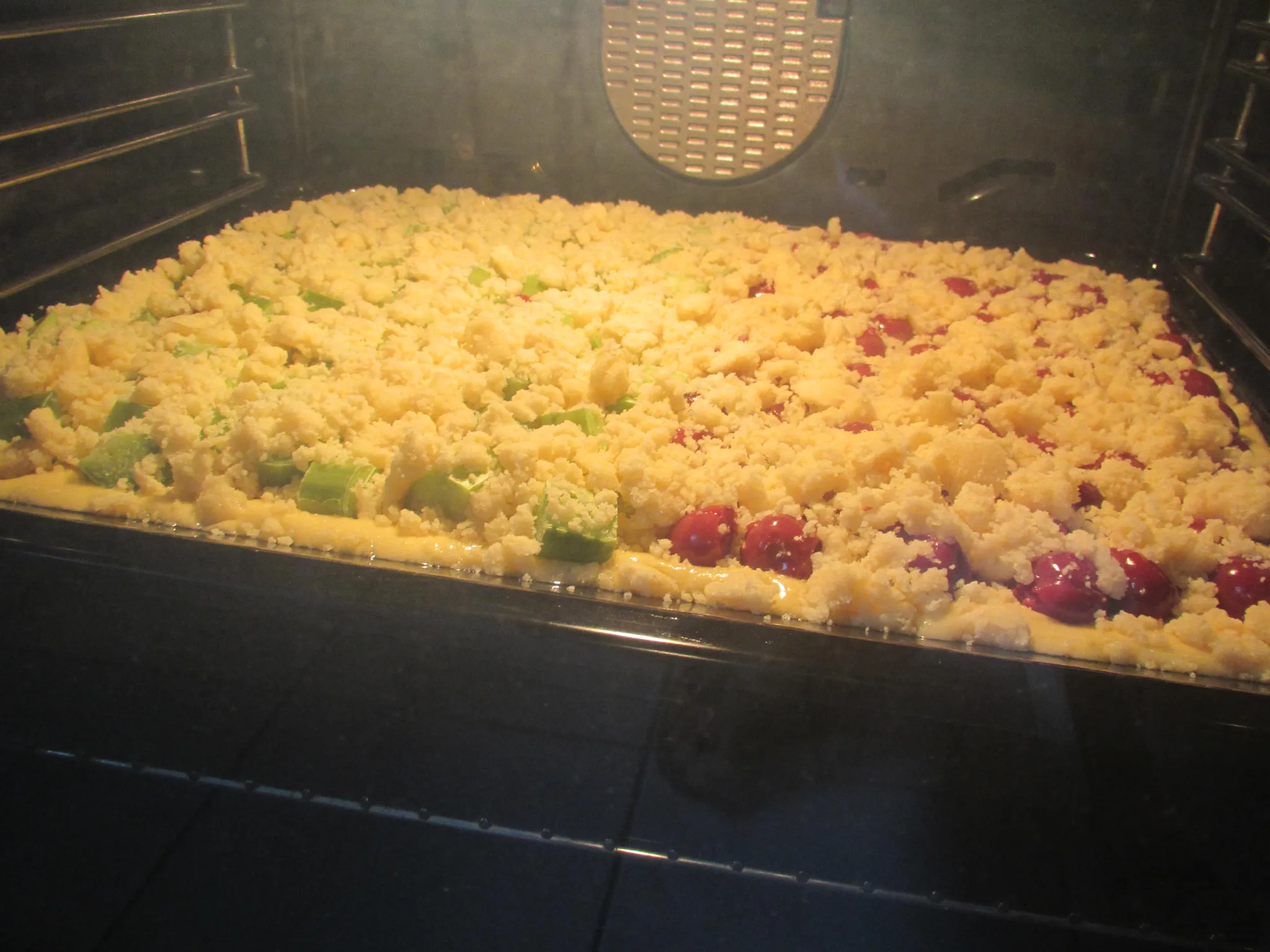 Die Streusel auf den Früchten verteilen.