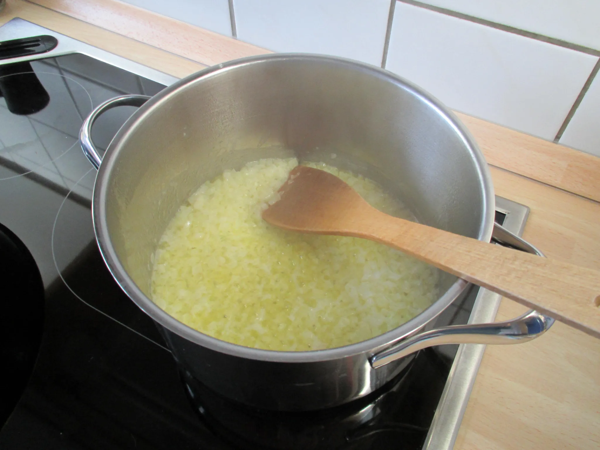 Zwiebeln in feine Würfel schneiden, in einem großen Topf in der Butter goldgelb anbraten.